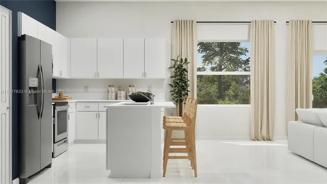 a kitchen with a refrigerator a stove a washer dryer and white cabinets