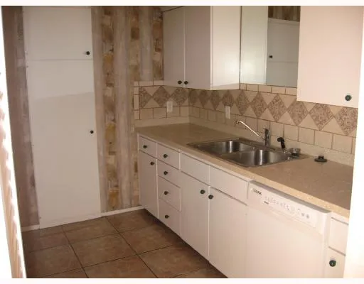 a kitchen with granite countertop white cabinets and sink