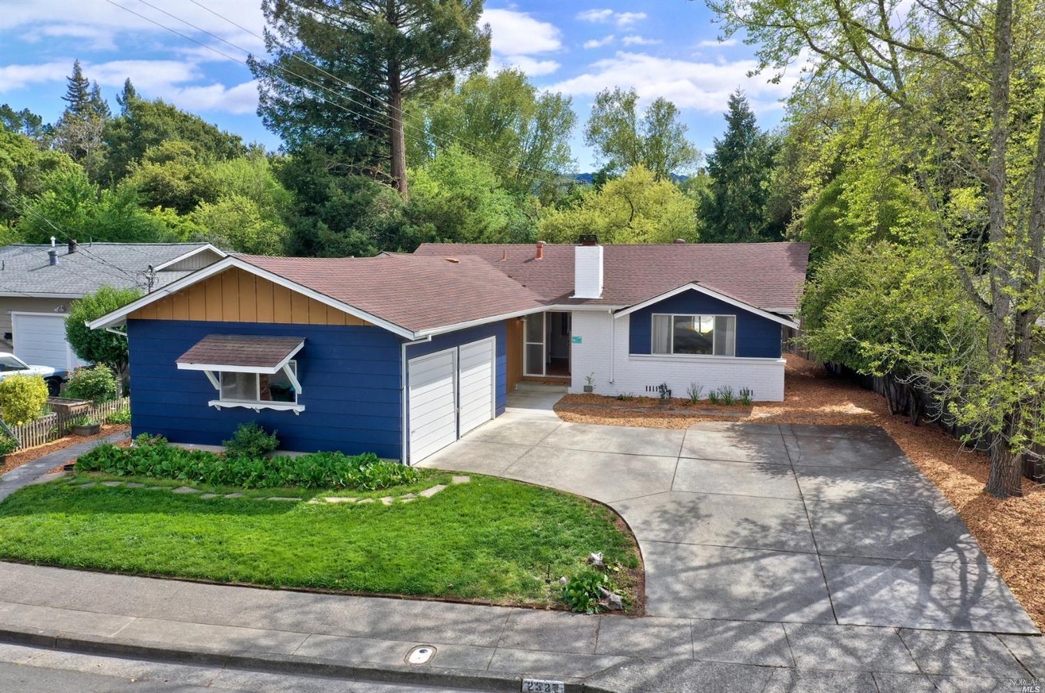 a aerial view of a house with a yard and large tree
