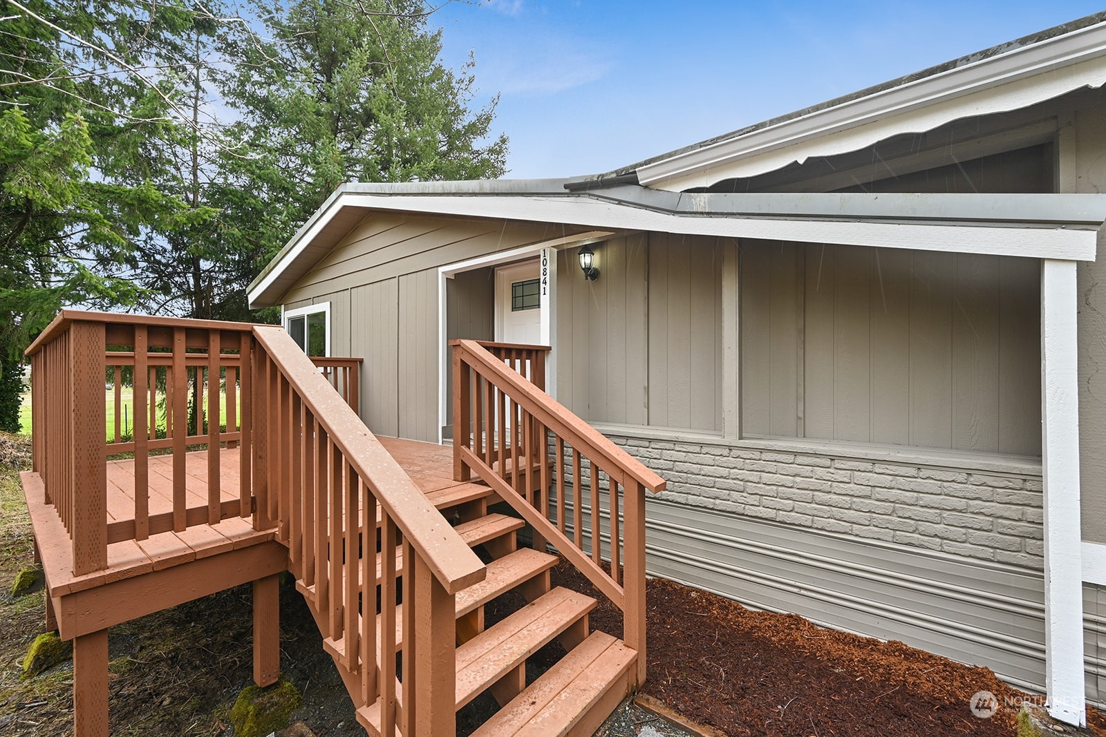 10841 Highway 12 Rochester, WA 98579 - Photo 23 of 23 a view of a house with wooden deck stairs and a floor to ceiling window