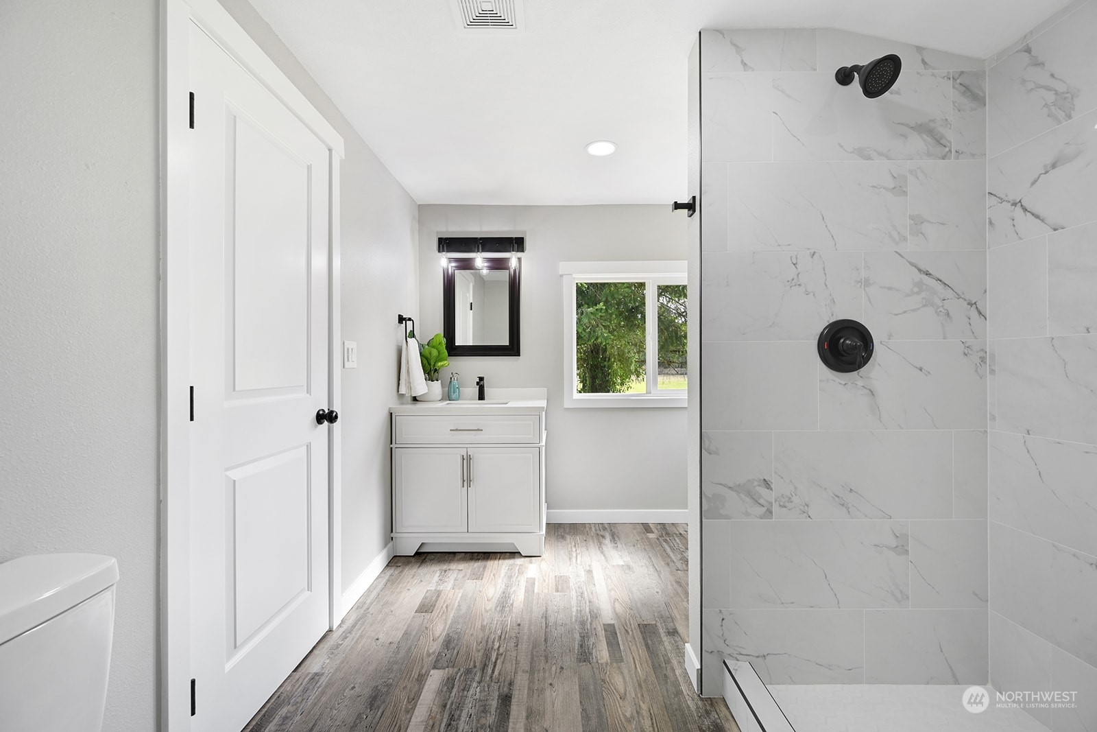 10841 Highway 12 Rochester, WA 98579 - Photo 8 of 23 a bathroom with a glass door shower a sink and a mirror