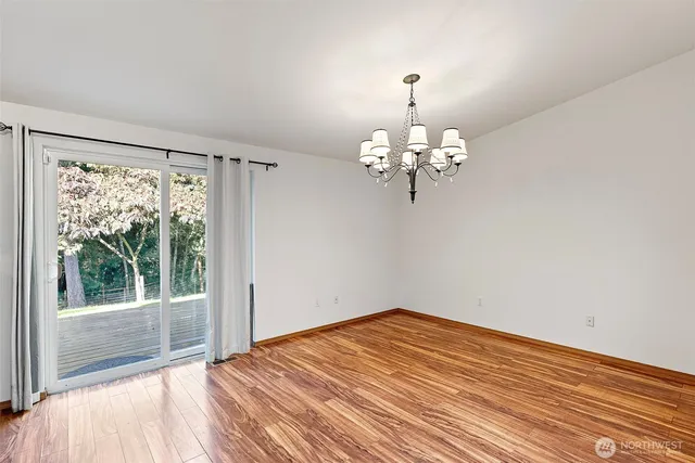 a view of a room with wooden floor and chandelier