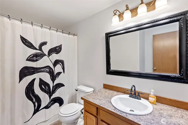 a bathroom with a sink a mirror a toilet and a mirror