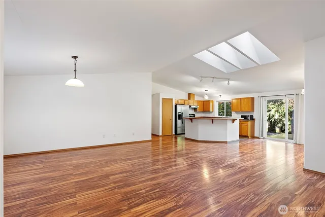 a view of a kitchen with wooden floor and a window