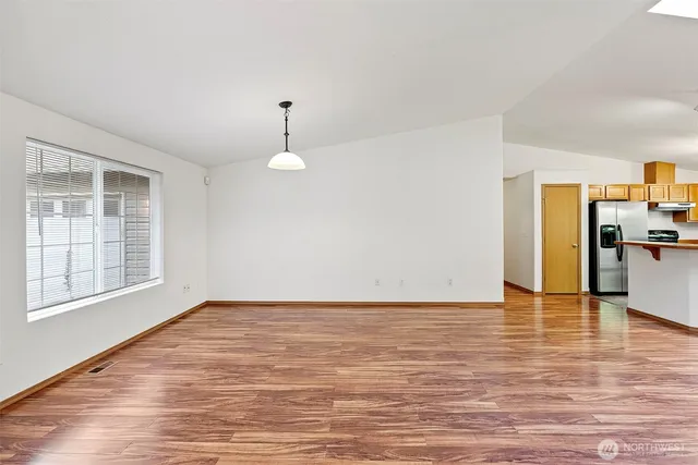 a view of empty room with wooden floor and fireplace