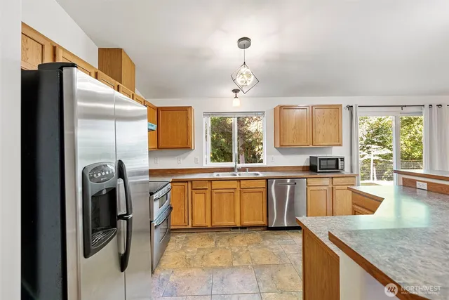 a kitchen with stainless steel appliances granite countertop a sink a stove and refrigerator