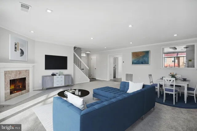 a living room with furniture a fireplace and a flat screen tv