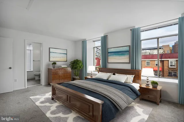 a bedroom with a bed a mirror and a window