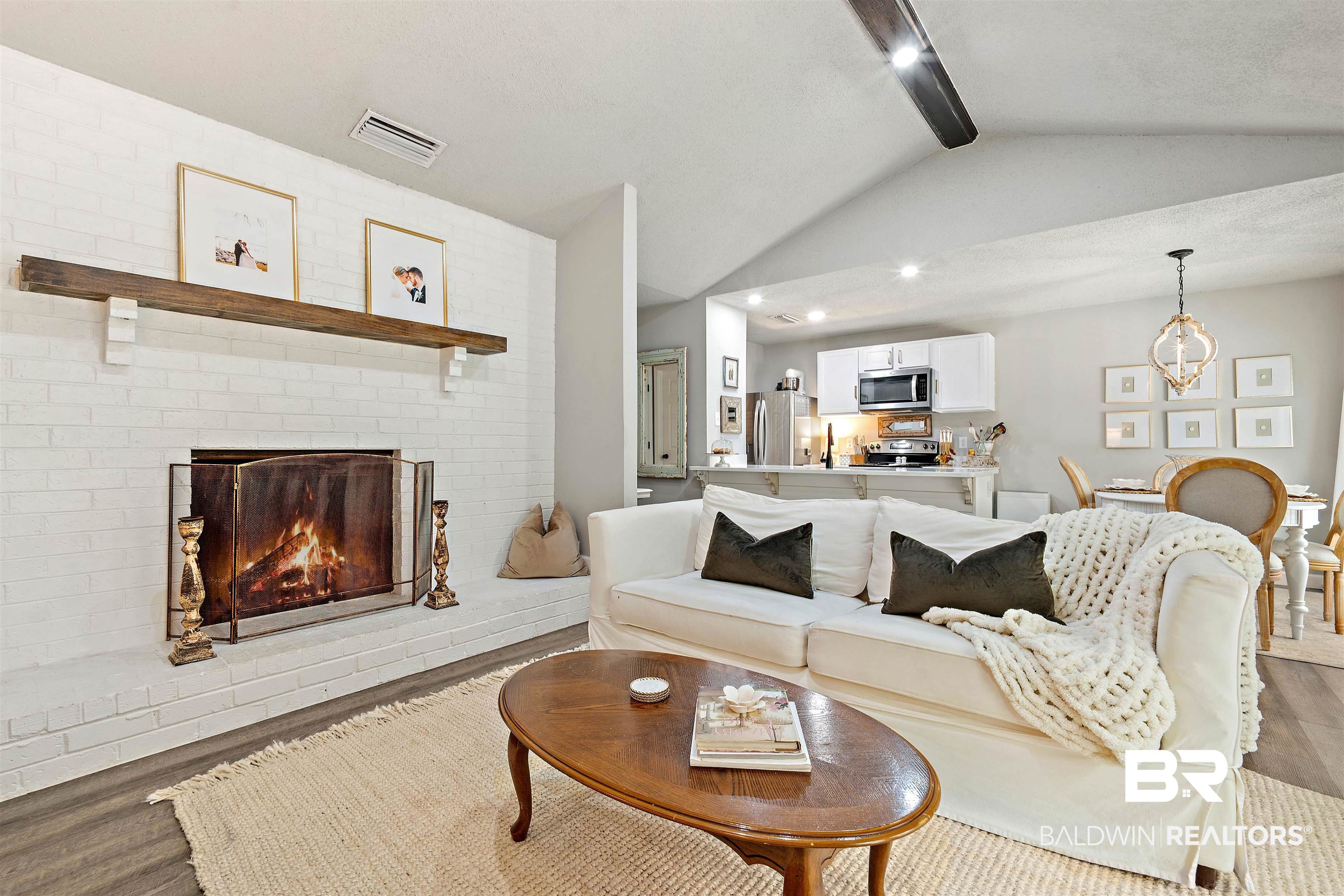 4682 Opal Drive Mobile, AL 36619 - Photo 6 of 27 Living room featuring brick wall, wood-type flooring, lofted ceiling with beams, and a fireplace