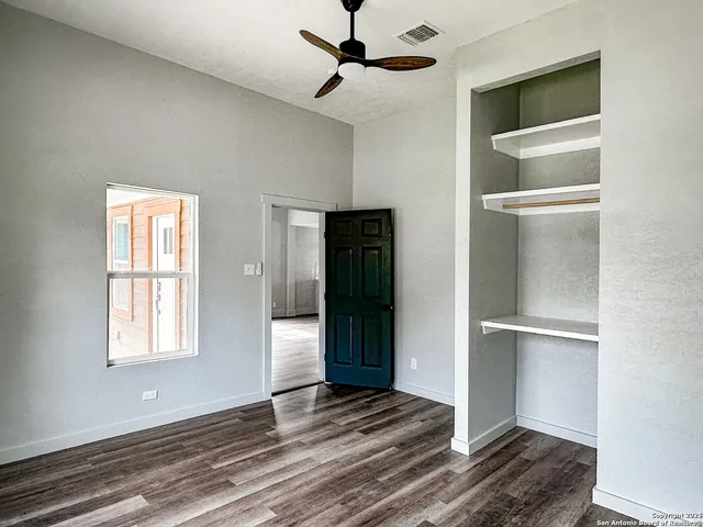 a view of an empty room with cabinet and a window