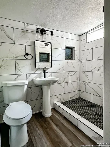 a bathroom with a sink a toilet and mirror