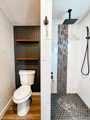 a bathroom with a toilet and a shower