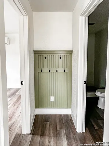 a view of an empty room with wooden floor stairs and a ceiling fan