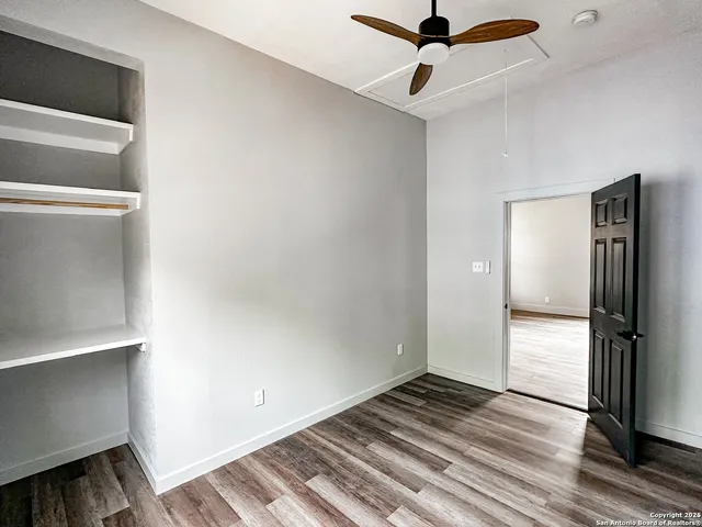 a view of an empty room with a window and a ceiling fan