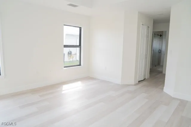 an empty room with windows and closet