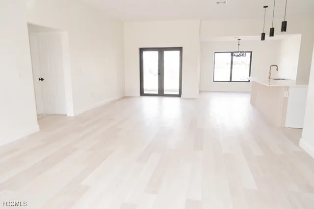 a view of a big room with wooden floor and windows