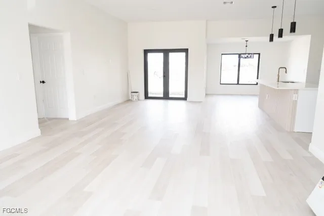 a view of a big room with wooden floor and windows
