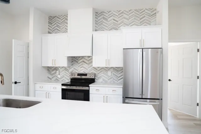 a kitchen with stainless steel appliances kitchen island a refrigerator sink and stove