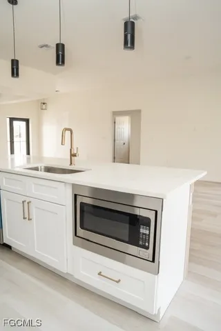 a kitchen with granite countertop white cabinets white stainless steel appliances and sink