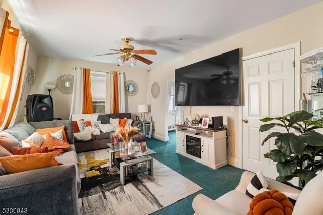 a living room with furniture a flat screen tv and a window