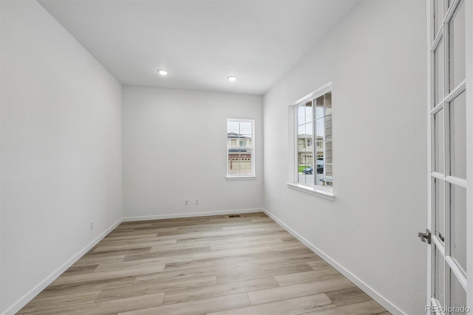 2516 West Bitterroot Place Highlands Ranch, CO 80129 - Photo 4 of 24 an empty room with wooden floor and windows