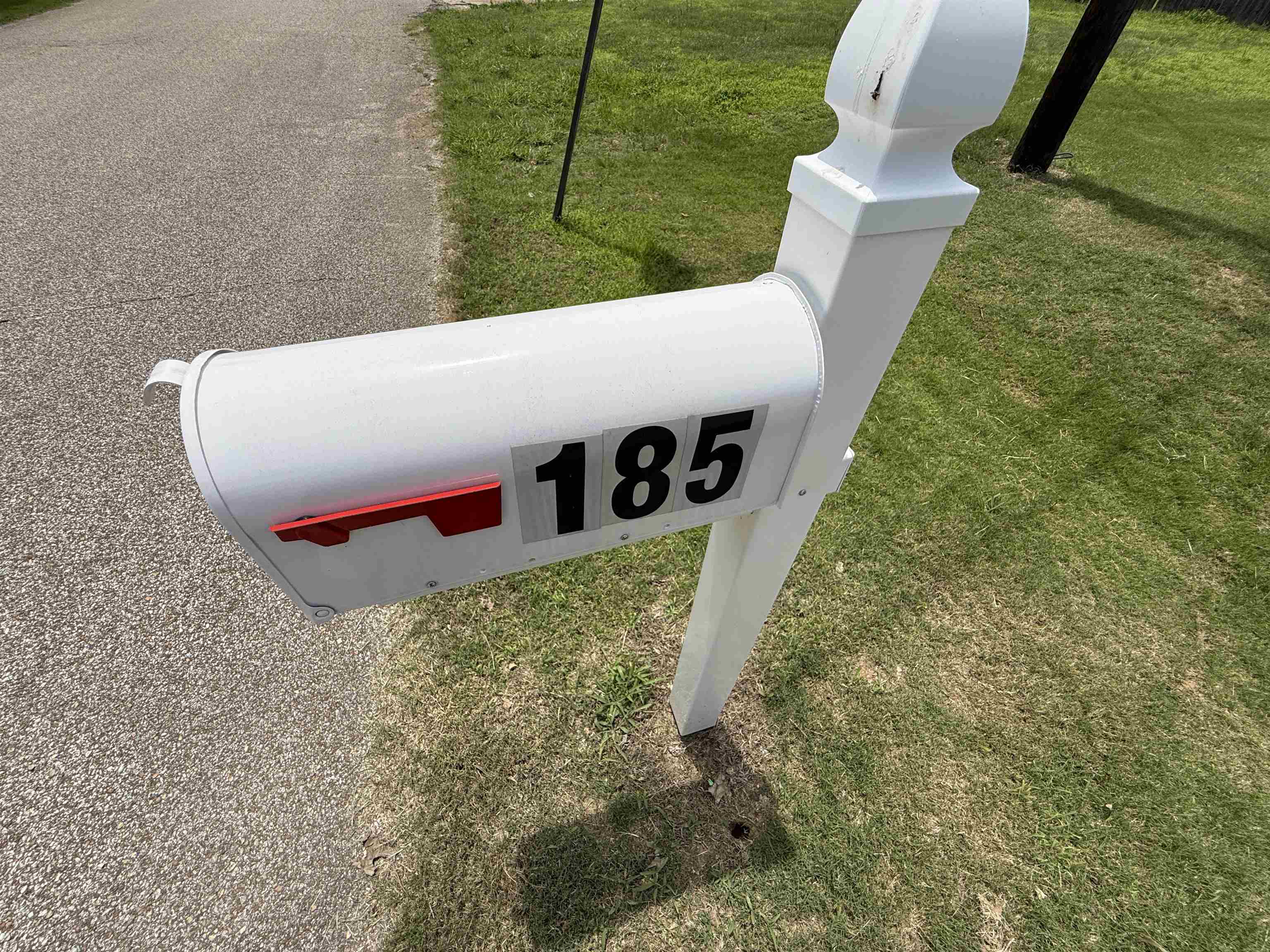 185 Mignon Road Atoka, TN 38004 - Photo 34 of 34 White mailbox featuring prominent address numbers and a red signal flag, supported by a decorative post