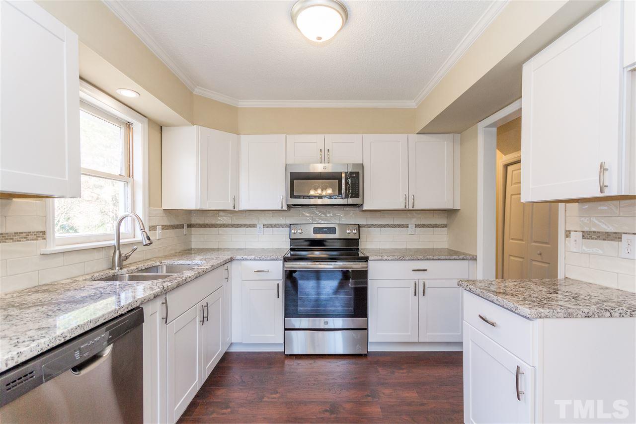 10616 Chelsea Drive Raleigh, NC 27603 - Photo 14 of 25 a kitchen with granite countertop a stove sink and microwave