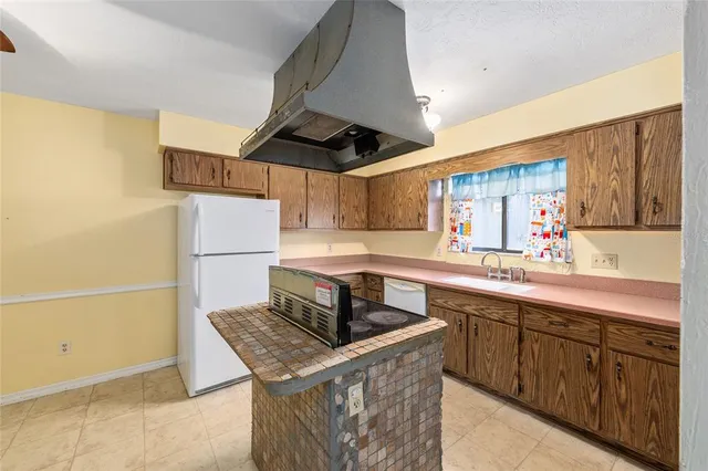 a kitchen with stainless steel appliances granite countertop a refrigerator a stove and a sink