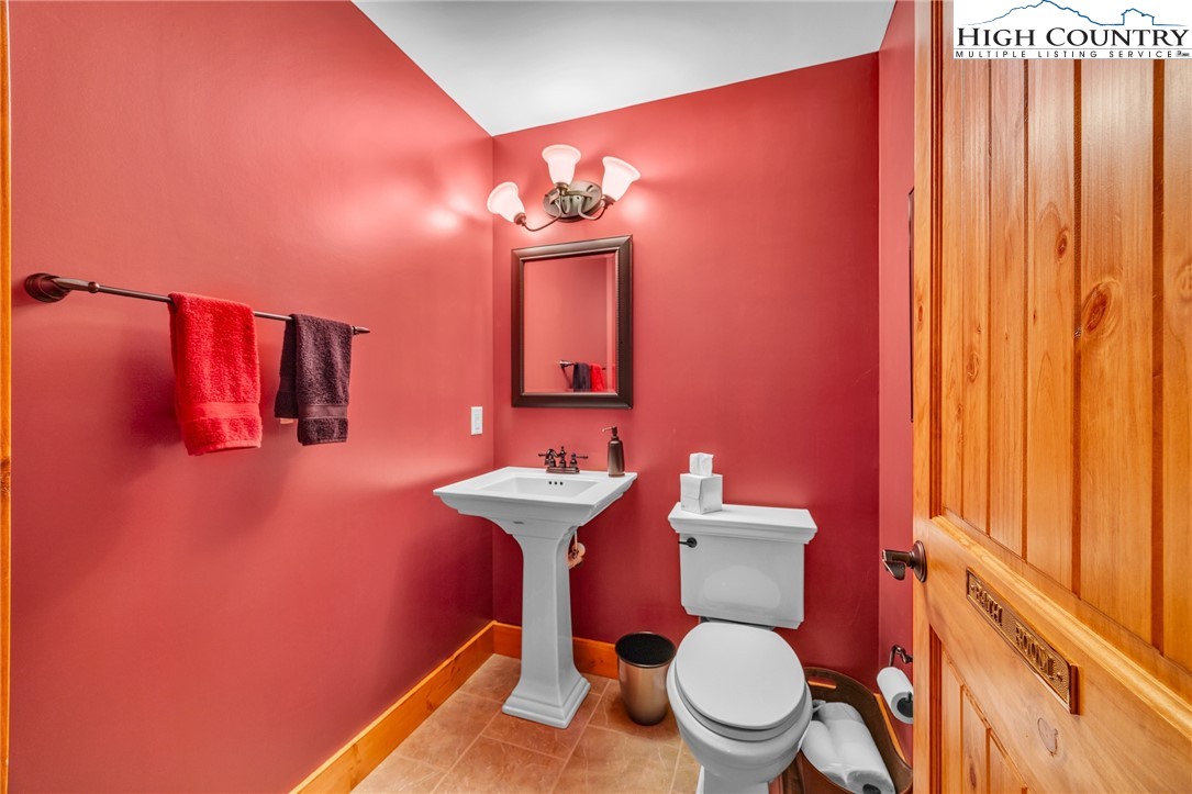 2650 Carson Woods Road Laurel Springs, NC 28644 - Photo 32 of 50 a bathroom with a toilet a sink and mirror