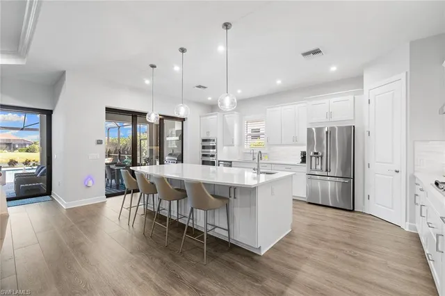 a large kitchen with kitchen island a white cabinets and stainless steel appliances