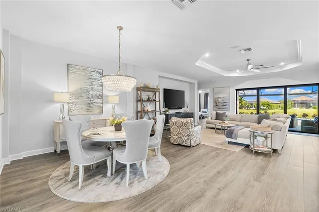 a dining room with furniture a chandelier and wooden floor