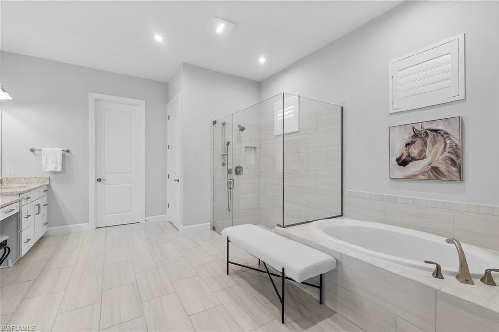 15345 Aprile Street Naples, FL 34114 - Photo 17 of 29 a spacious bathroom with a bathtub and a shower