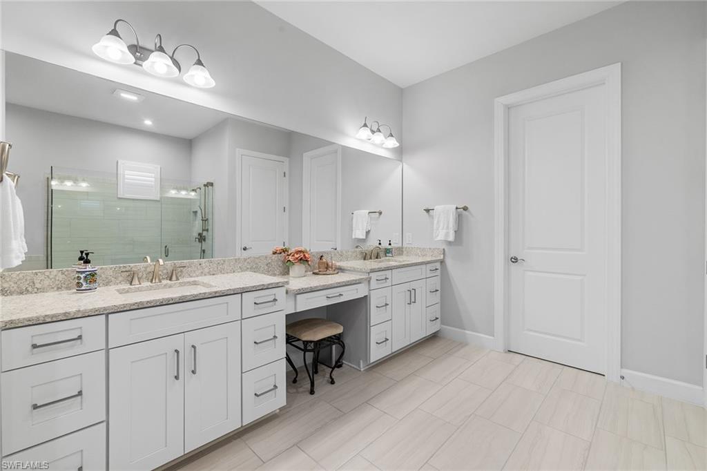 15345 Aprile Street Naples, FL 34114 - Photo 18 of 29 a bathroom with a double vanity sink double and mirror