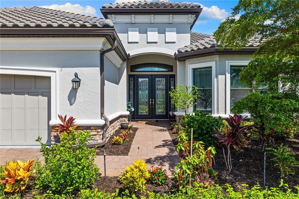 15345 Aprile Street Naples, FL 34114 - Photo 2 of 29 a front view of a house with potted plants