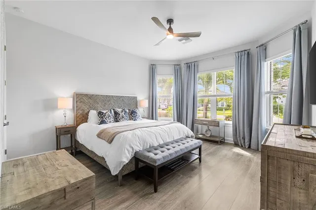 a bed sitting in a spacious bedroom next to a window