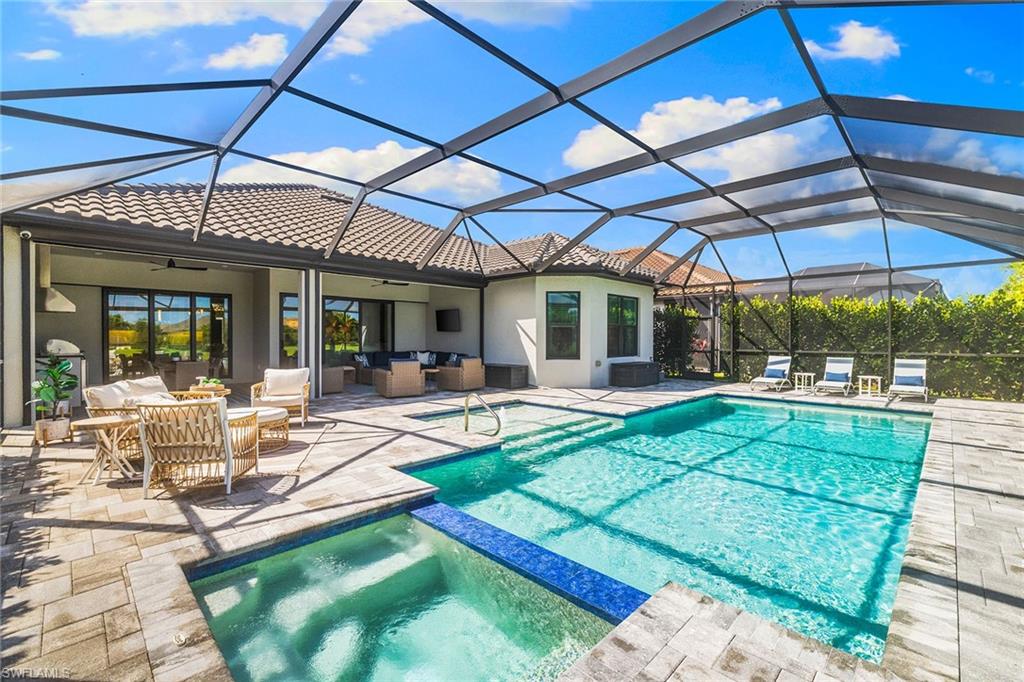 15345 Aprile Street Naples, FL 34114 - Photo 25 of 29 a view of a backyard with dining table and chairs under an umbrella