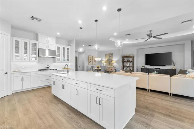 a large white kitchen with cabinets and wooden floor