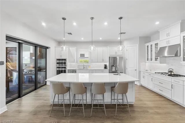 a large kitchen with kitchen island a dining table and chairs