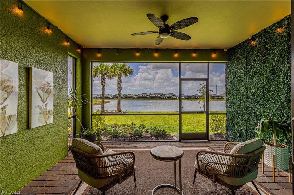 Sunroom / solarium with a water view and a ceiling fan
