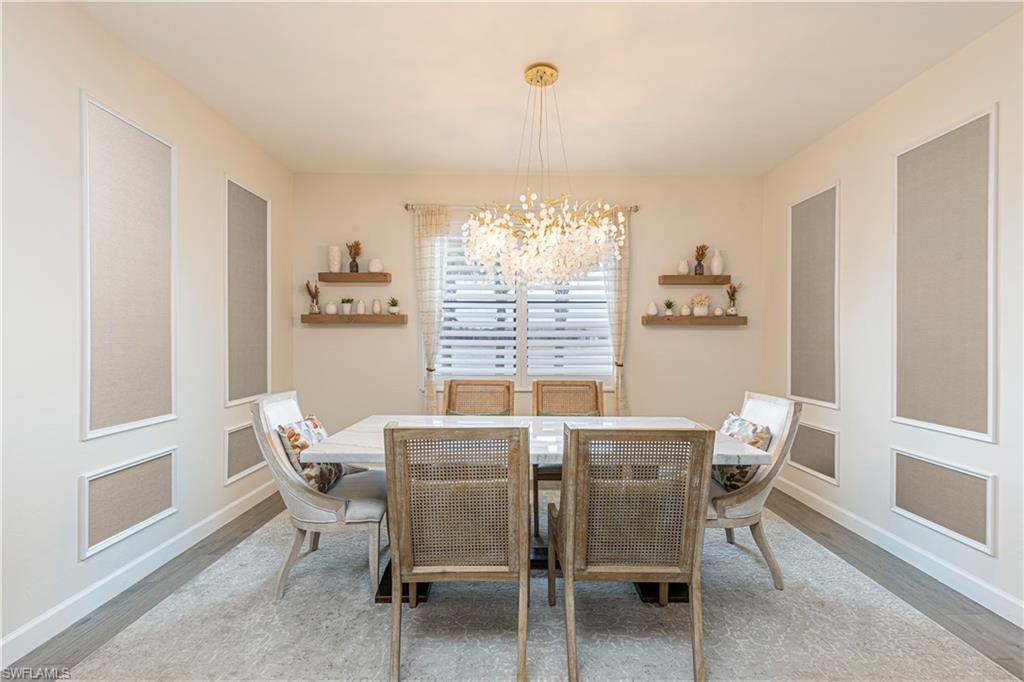20278 Kingmont Drive Estero, FL 33928 - Photo 11 of 38 Dining room featuring a chandelier, baseboards, and wood finished floors