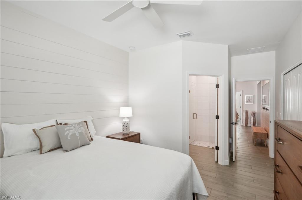 20278 Kingmont Drive Estero, FL 33928 - Photo 14 of 38 Bedroom featuring visible vents, light wood-type flooring, ensuite bathroom, and a ceiling fan