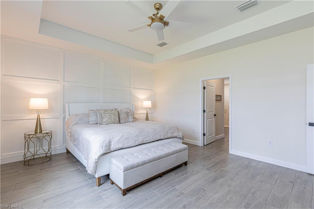 20278 Kingmont Drive Estero, FL 33928 - Photo 20 of 38 Bedroom with light wood-style floors, a decorative wall, baseboards, and visible vents