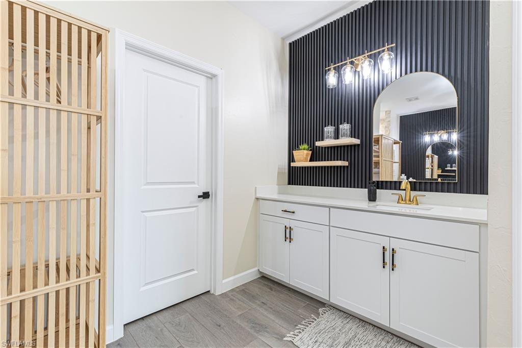 20278 Kingmont Drive Estero, FL 33928 - Photo 22 of 38 Bathroom featuring vanity, baseboards, and wood finished floors