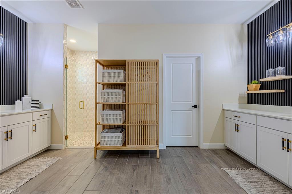 20278 Kingmont Drive Estero, FL 33928 - Photo 23 of 38 Bathroom with vanity, baseboards, a shower stall, visible vents, and wood finished floors