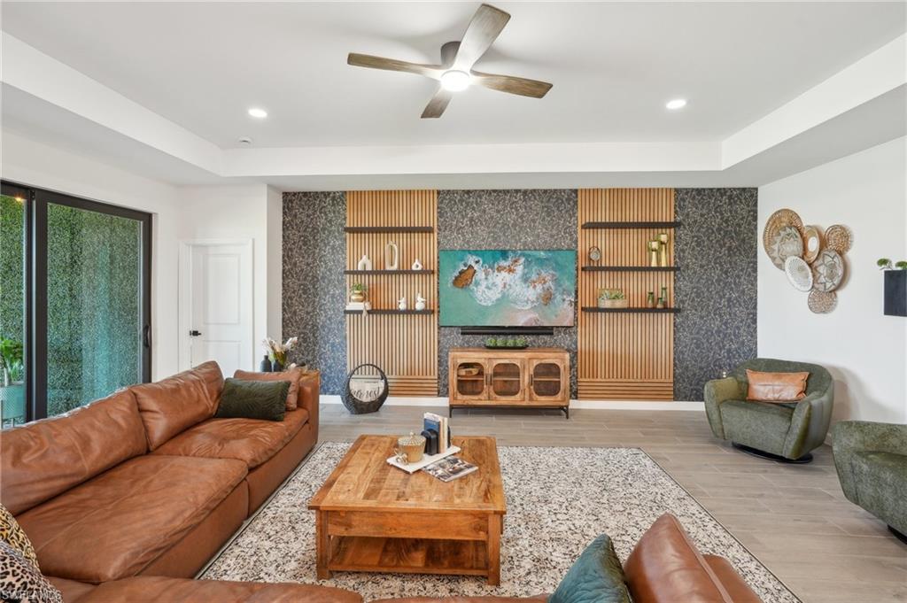 20278 Kingmont Drive Estero, FL 33928 - Photo 7 of 38 Living area featuring an accent wall, wood finished floors, a ceiling fan, and recessed lighting
