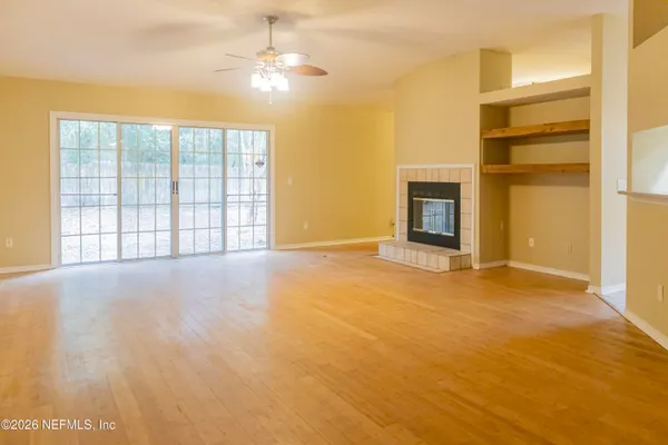 a view of an empty room with a window and fireplace