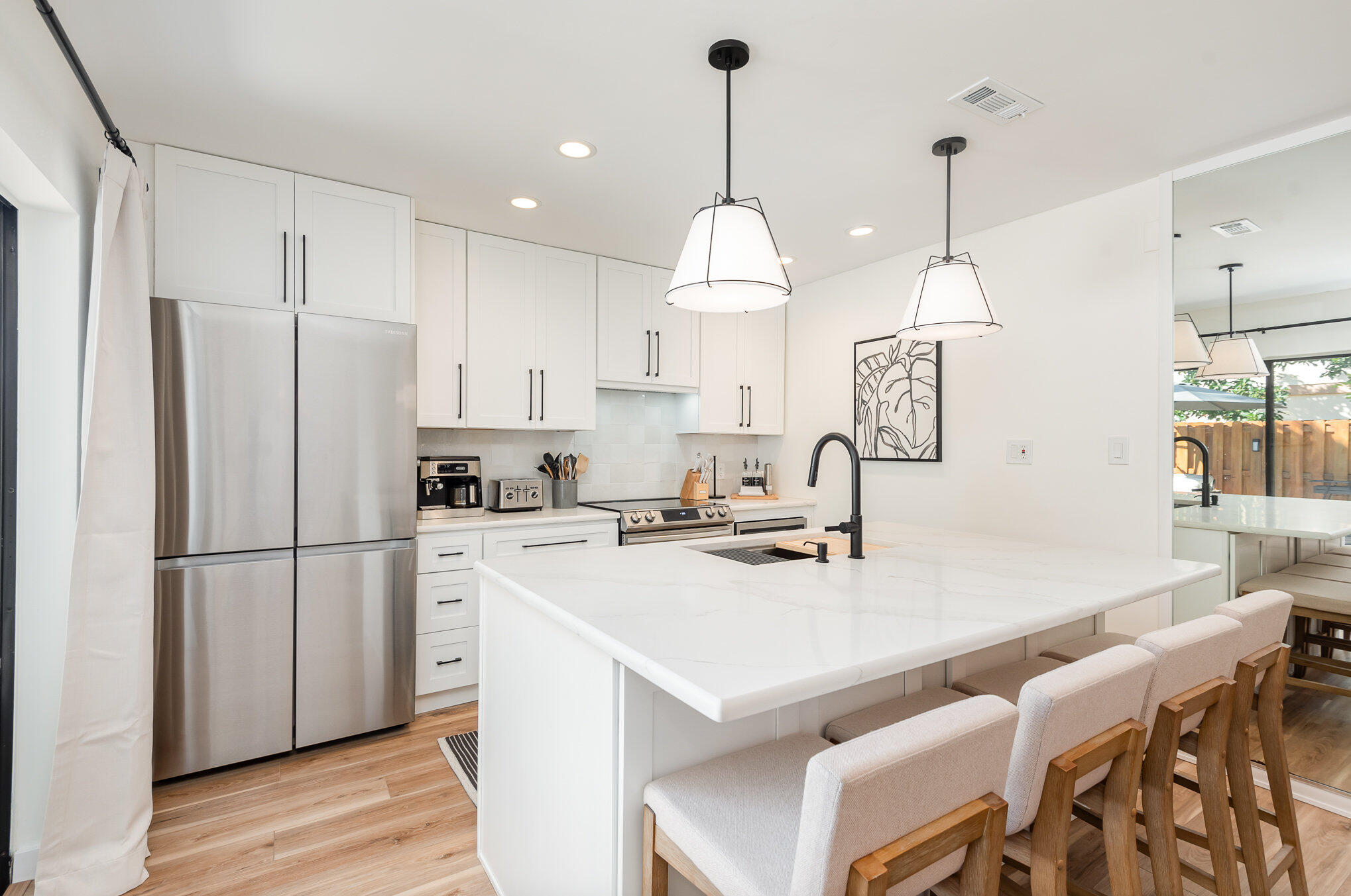 200 South Banana River Boulevard, Unit 804 Cocoa Beach, FL 32931 - Photo 6 of 31 a kitchen with kitchen island a stove a refrigerator a sink a dining table and chairs with wooden floor