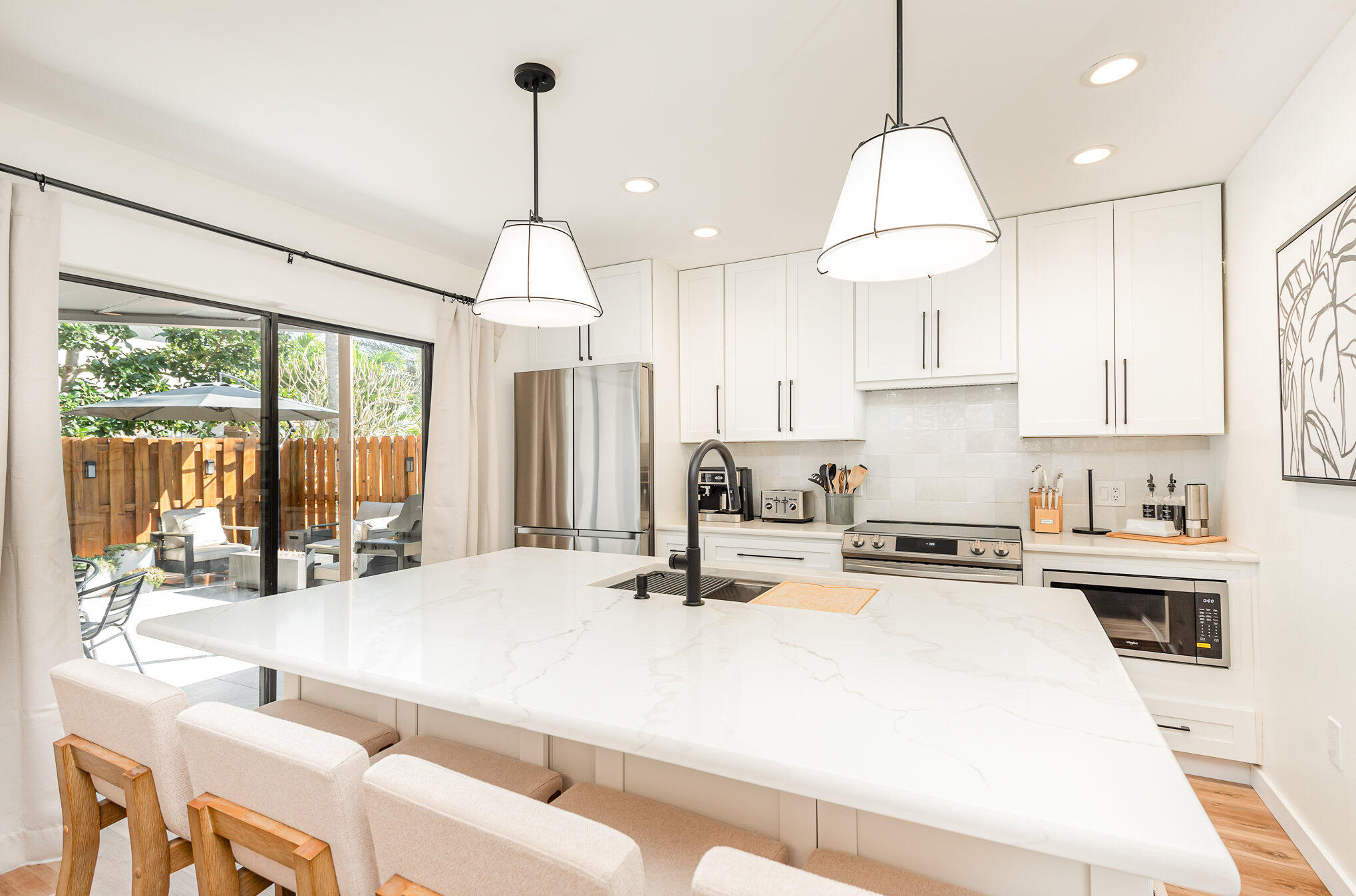 200 South Banana River Boulevard, Unit 804 Cocoa Beach, FL 32931 - Photo 7 of 31 a kitchen with kitchen island a large counter top space a sink appliances and cabinets