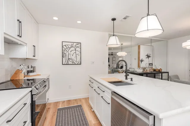 a kitchen with a sink a stove and cabinets