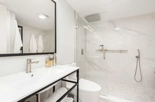 a bathroom with a sink a toilet and shower